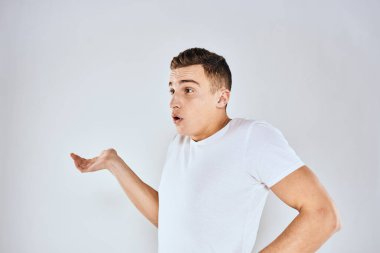 Beyaz tişörtlü hoş bir adam elleriyle jestler yapıyor. Duyguları stüdyoyu şaşırtıyor.