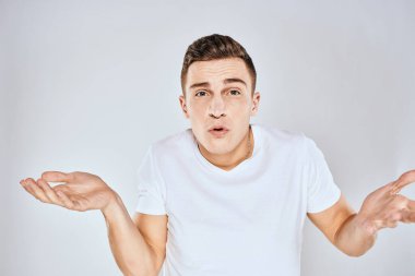 Beyaz tişörtlü hoş bir adam elleriyle jestler yapıyor. Duyguları stüdyoyu şaşırtıyor.