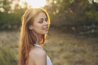 Dışarıda bahçede çekici bir kadın gün batımı taze hava ağaçları