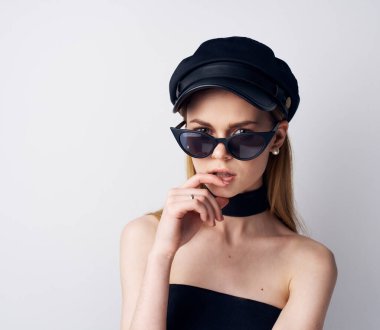 Siyah şapkalı zarif bir kadın. Güneş gözlüklü. Gece elbisesi büyüleyici.