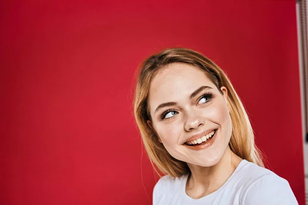 Mooie vrouw glimlach wit t-shirt bijgesneden takken rood achtergrond — Stockfoto