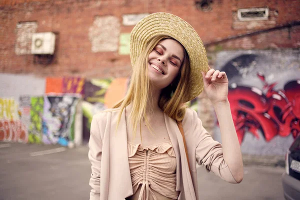 Glada kvinna med hatt utomhus urban stil graffiti utomhus — Stockfoto