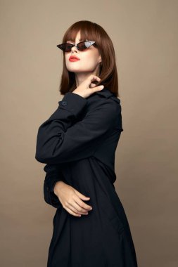 Çekici bayan modaya uygun kıyafetler. İçerde gülümsüyor. 