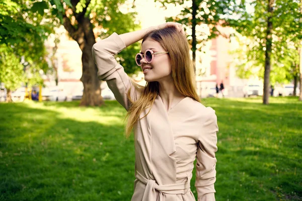 Wesoła piękna kobieta w okularach przeciwsłonecznych na świeżym powietrzu w parku — Zdjęcie stockowe
