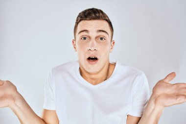 Beyaz tişörtlü hoş bir adam elleriyle jestler yapıyor. Duyguları stüdyoyu şaşırtıyor.