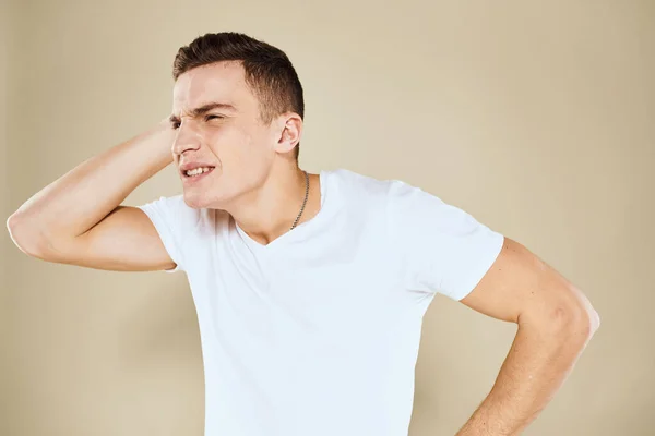 Emotional man facial expression gesture with hands white t-shirt beige background — Stock Photo, Image