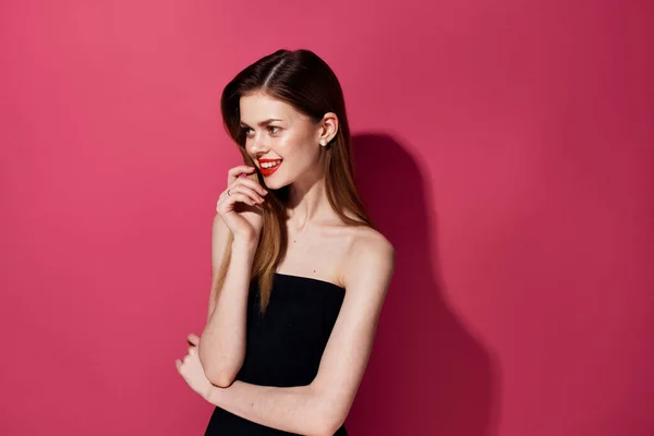Aantrekkelijke vrouw rode lippen glamour luxe zwart jurk roze achtergrond — Stockfoto