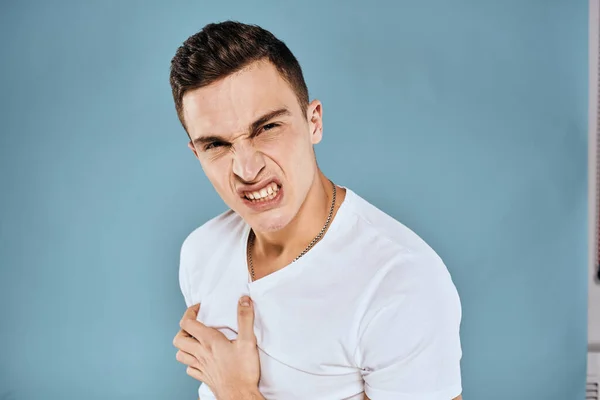 Ο άνθρωπος χειρονομίες με τα χέρια του συναισθήματα λευκό t-shirt έκφραση μπλε φόντο — Φωτογραφία Αρχείου