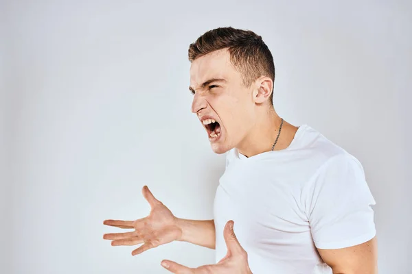 Homme en t-shirt blanc expression du visage mécontent geste avec les mains style de vie studio — Photo