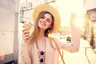 Güzel bir kadın, elinde dondurmayla şehirde dolaşıyor.