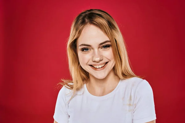 Mulher bonita sorriso branco t-shirt cortada ramos vermelho fundo — Fotografia de Stock