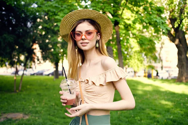 Красивая женщина в шляпе в парке зеленая трава ходить весело — стоковое фото