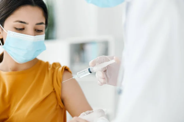 Hermosa mujer en máscara médica para su examen por el médico la vacunación guantes de protección tratamiento de inyección —  Fotos de Stock