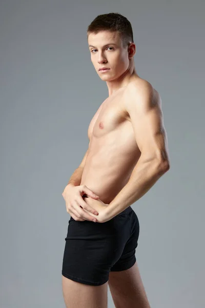Atleta masculino esportivo calcinha preta posando treino corpo muscular — Fotografia de Stock