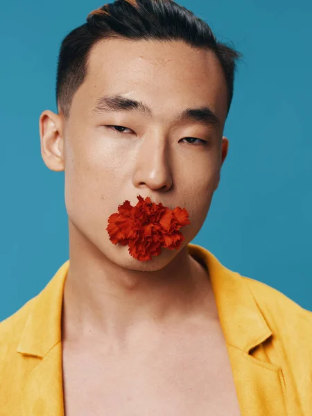 青い背景に花を咲かせたロマンチックな韓国人男性 — ストック写真