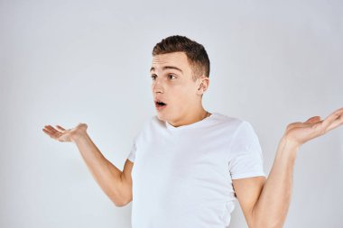 Beyaz tişörtlü hoş bir adam elleriyle jestler yapıyor. Duyguları stüdyoyu şaşırtıyor.