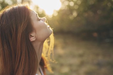 Dışarıda bahçede çekici bir kadın gün batımı taze hava ağaçları