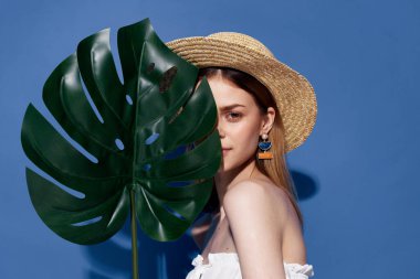 Şapkalı kadın ellerinde lüks egzotik mavi arka plan