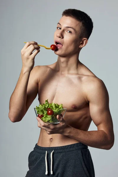 Atletico ragazzo con busto muscolare mangiare insalata dieta cibo sano — Foto Stock