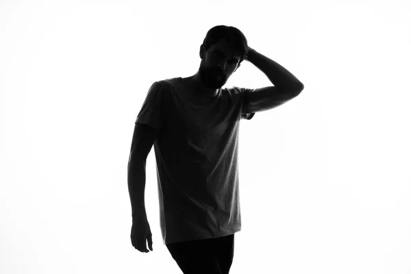 Die dunkle Silhouette eines Mannes gestikuliert mit seinen Händen vor weißem Hintergrund. — Stockfoto