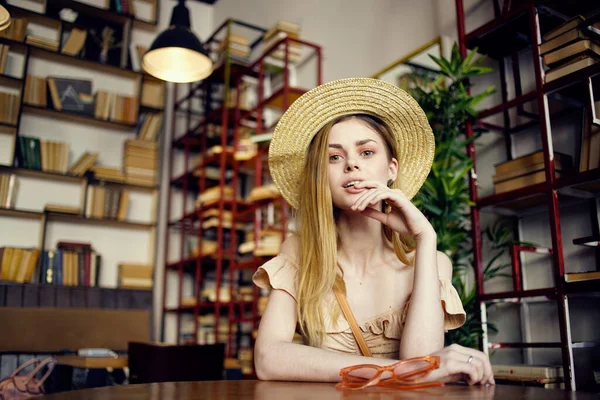 Όμορφη γυναίκα σε ένα καπέλο κάθεται σε ένα τραπέζι σε ένα καφέ διακοπές βιβλίο διασκέδαση — Φωτογραφία Αρχείου