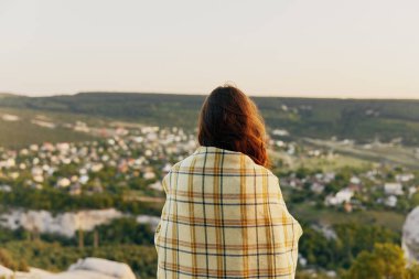 Ekose kumaşlı güzel bir kadın doğa manzarasına bakıyor.