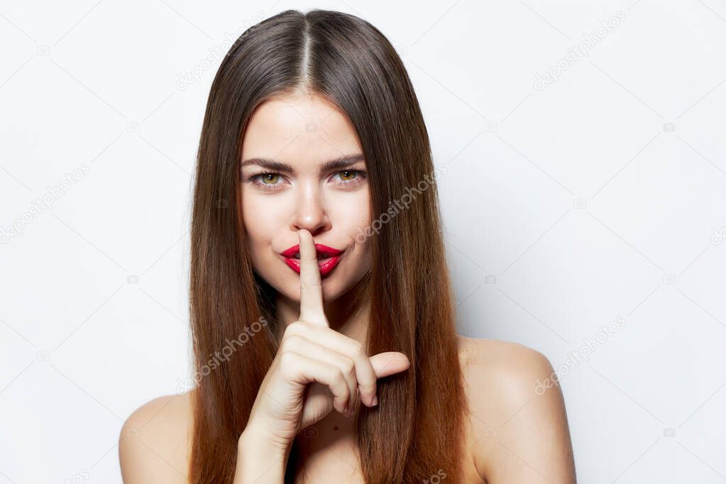 Sexy woman holds his finger near his lips and classified information clear skin Copy space