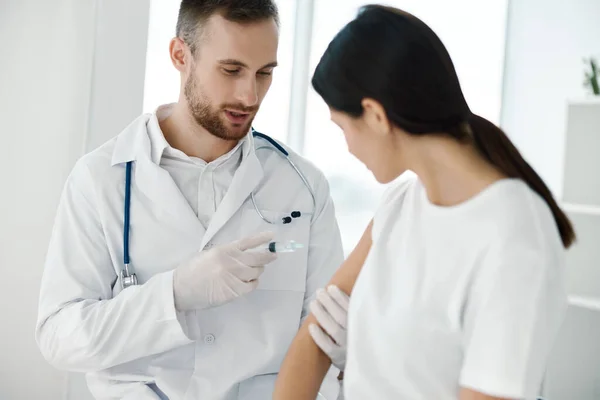 Genç doktor hastalara aşı enjekte ediyor. Omuz ve şırınga ellerinde steteskop laboratuvarı ile. — Stok fotoğraf