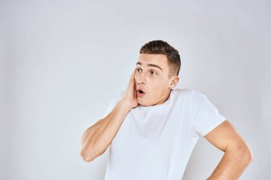 Beyaz tişörtlü hoş bir adam elleriyle jestler yapıyor. Duyguları stüdyoyu şaşırtıyor.