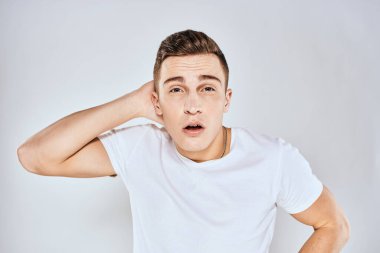 Beyaz tişörtlü hoş bir adam elleriyle jestler yapıyor. Duyguları stüdyoyu şaşırtıyor.