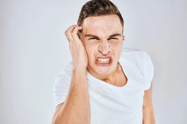 Emotionell man gest med händerna missnöjd ansiktsuttryck vit t-shirt beskärs — Stockfoto