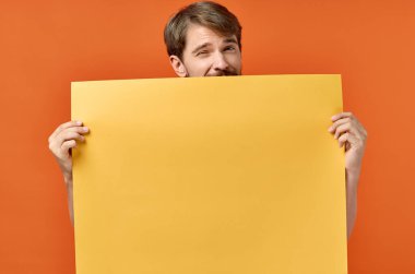 Reklam tabelası. Arka planda posterci adam. Turuncu arkaplan kopyalama alanı.
