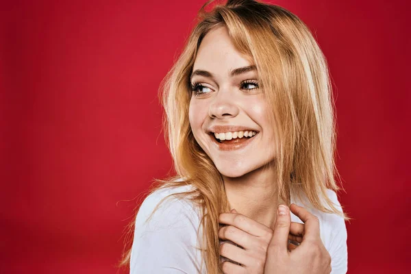 Mooie vrouw glimlach wit t-shirt bijgesneden takken rood achtergrond — Stockfoto