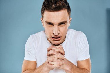 duygusal hoşnutsuz adam beyaz tişört mavi arka plan kırptı