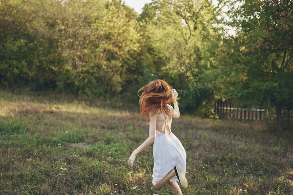 Mulheres felizes em um vestido de verão corre em grama verde no prado e árvores No fundo — Fotografia de Stock