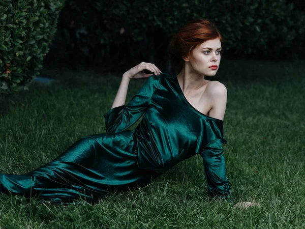 Nő luxus zöld ruha fekszik a fű hercegnő karnevál — Stock Fotó