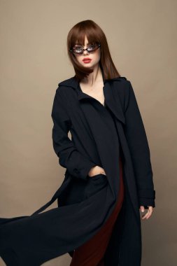 Koyu renk ceketli güzel bayan gülümsüyor bej arka planda 