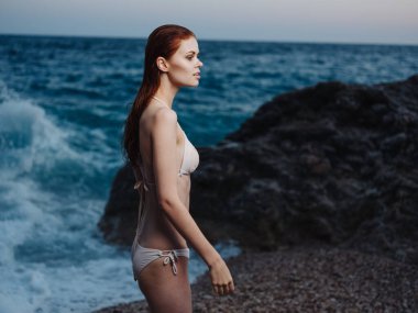 Beyaz mayo giymiş zarif bir kadın Çıplak Omuzlar Şeffaf Su Okyanusu Sahil Doğası