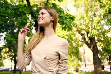 Yeşil ağaçların arasında güzel bir kadın dinleniyor.