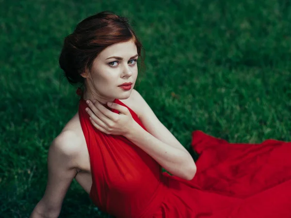 Nő piros ruhában zöld fű park luxus báj modell — Stock Fotó