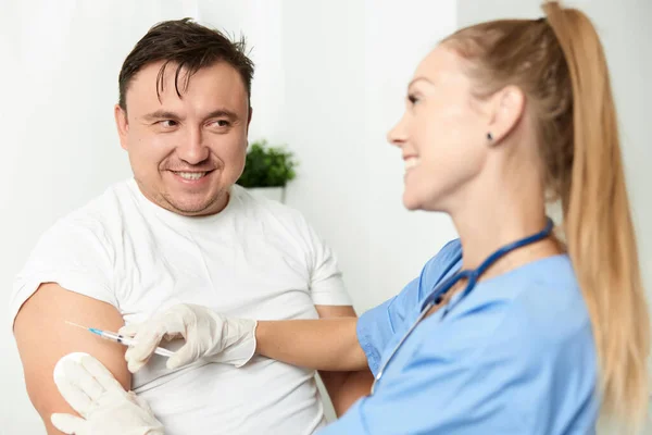 Manlig patient bredvid läkare kvinna injektion hälsa covid vaccination — Stockfoto