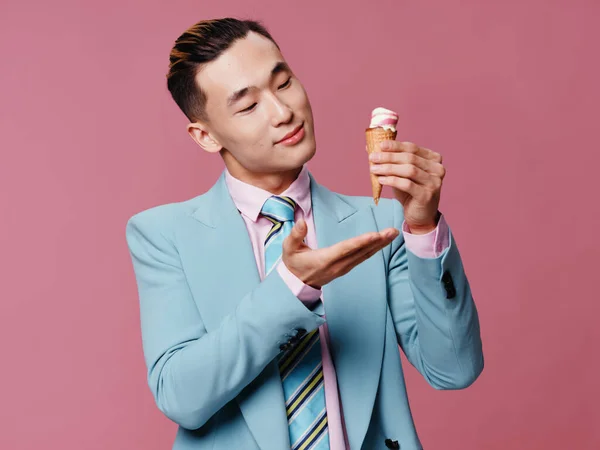 Vidám férfi ázsiai megjelenés kék öltöny és fagylalt rózsaszín háttér — Stock Fotó