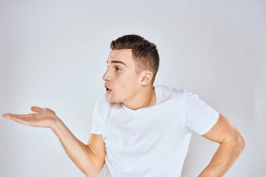 Beyaz tişörtlü hoş bir adam elleriyle jestler yapıyor. Duyguları stüdyoyu şaşırtıyor.