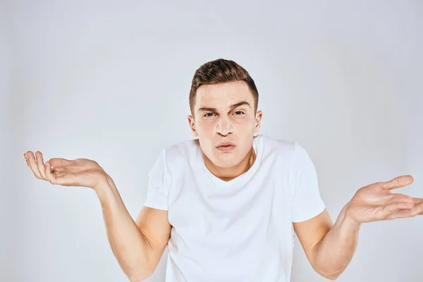 Nice man in a white t-shirt gestures with his hands emotions surprise studio — Stock Photo, Image