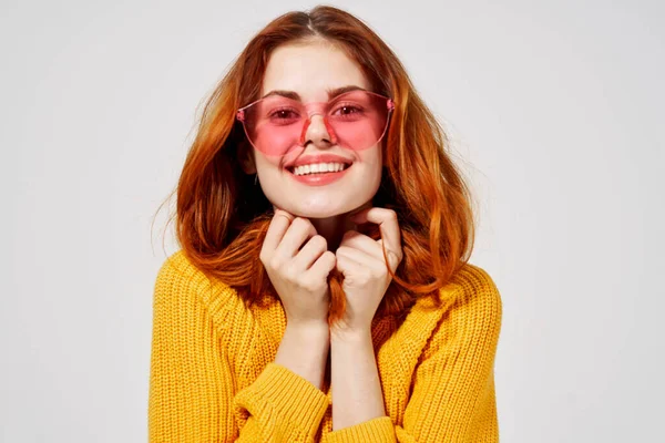 Mulher bonita alegre vestindo óculos rosa e segurando seu cabelo sorriso amarelo suéter close-up — Fotografia de Stock