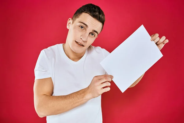 Man holding white sheet copy space office close-up red background — Stock Photo, Image