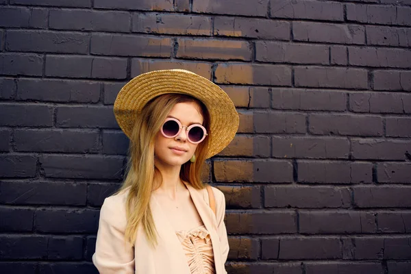 Элегантная женщина в солнечных очках на улице ходить кирпичный фон в городском стиле — стоковое фото