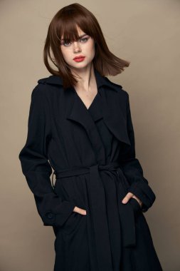 Çekici esmer, koyu renk ceketli, zarif, gülümseyen bir stüdyo. 