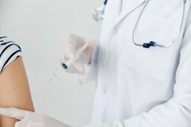 Doktor omuz aşısı için iğne yapıyor.