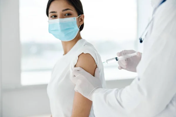 戴医疗面罩的女病人和医生用注射器注射疫苗预防感染 — 图库照片